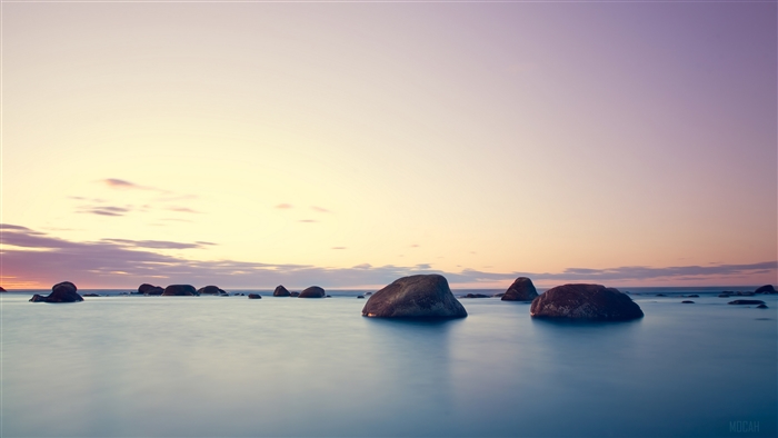 Rocks in the ocean at sunset 4K