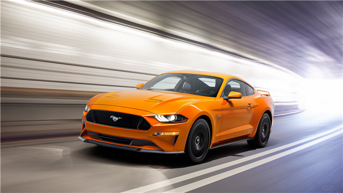Orange Ford Mustang GT driving through a tunnel