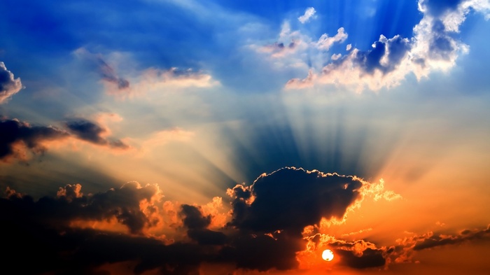 Sunbeams shining through clouds at sunset