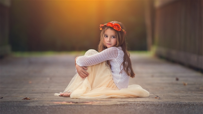 Little Girl with Flower Crown Sitting on Wooden Path