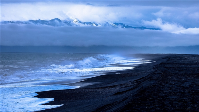 Black Sand Beach with Waves and Snow-Capped Mountains