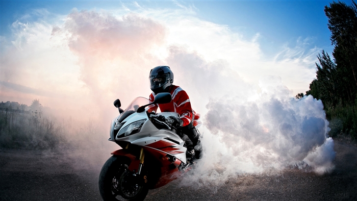Motorcycle rider performing a burnout in smoke
