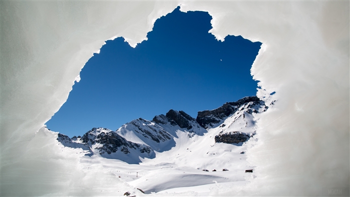 Snowy mountains viewed through an ice frame in Switzerland 4K