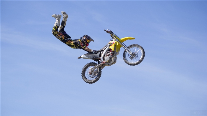 Motocross rider performing a trick on a Suzuki motorcycle