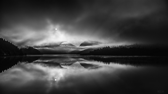 Monochrome lake reflection with clouds and sun