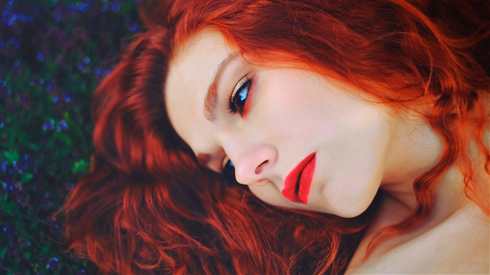 Woman with red hair and blue eyes wearing red lipstick