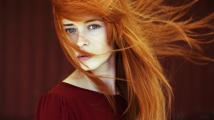 Woman with flowing red hair and blue eyes