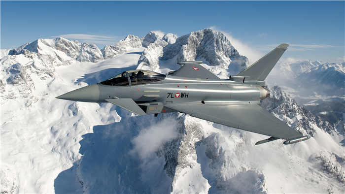 Eurofighter Typhoon flying over snowy mountains