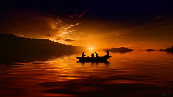 Silhouette of people in a canoe at sunset