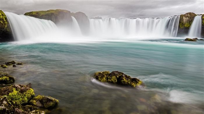 Waterfall with turquoise water and mossy rocks