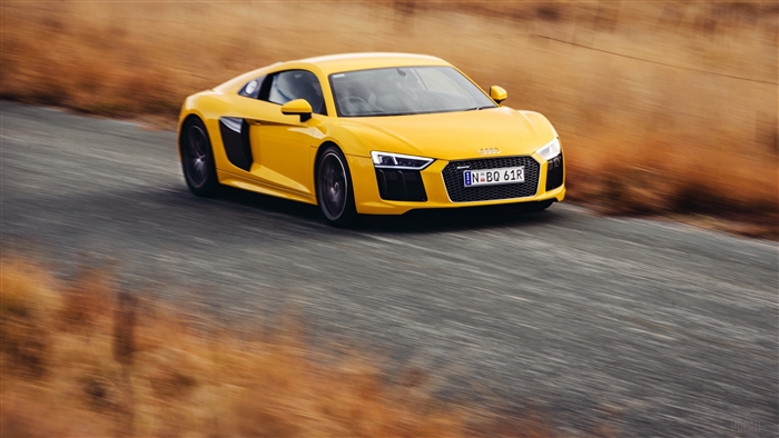 Yellow Audi R8 V10 driving on a road