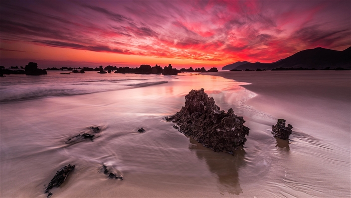 Beach with rocks at sunset 4K