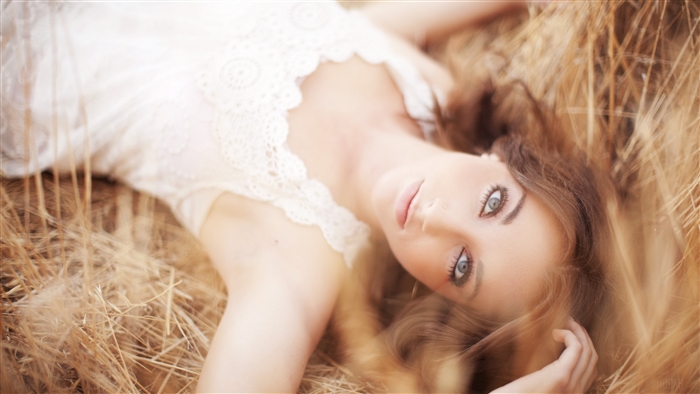 Woman lying in dry grass