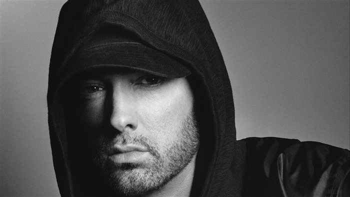 Eminem wearing a hood and baseball cap