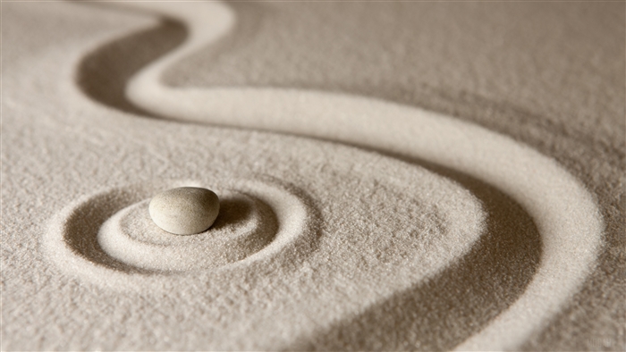 Close-Up of Stone on Sand with Zen Rake Patterns 4K