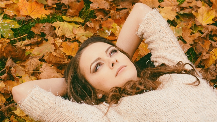Woman lying down in autumn leaves