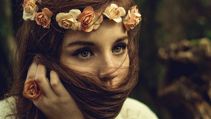 Woman with flower wreath and hair covering face