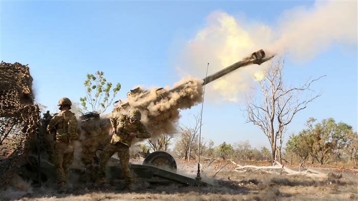 Soldiers firing M777 howitzer artillery