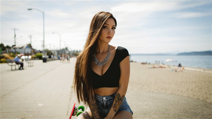 Woman with tattoos and necklace on a boardwalk