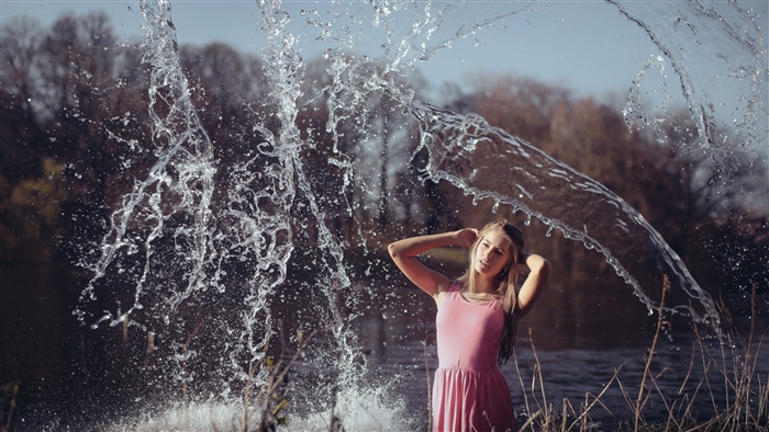 Girl in pink dress splashing water