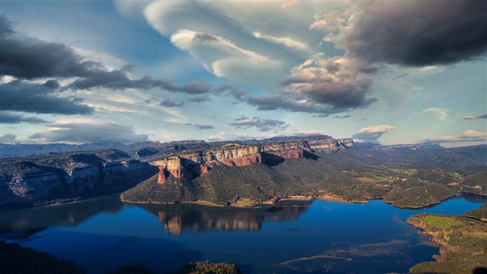 Mountain lake with dramatic clouds and canyon