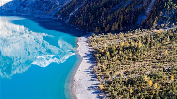 Turquoise lake reflecting mountains and forest