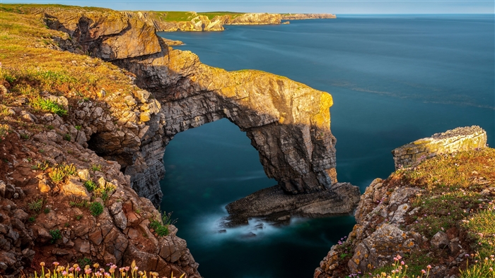 Natural Arch on a Rocky Coastline Overlooking the Ocean 4K