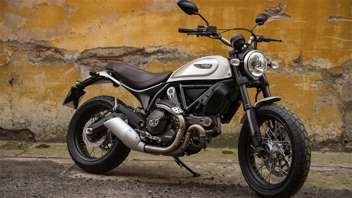 Ducati Scrambler motorcycle parked against a textured wall