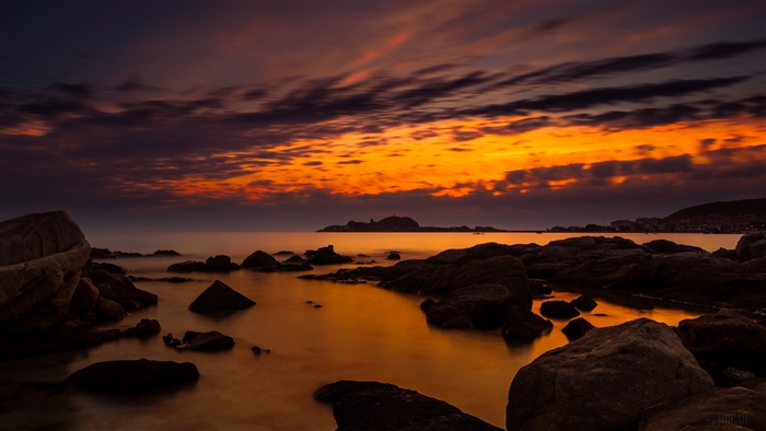 Sunset over the ocean with rocks in Corsica 4K