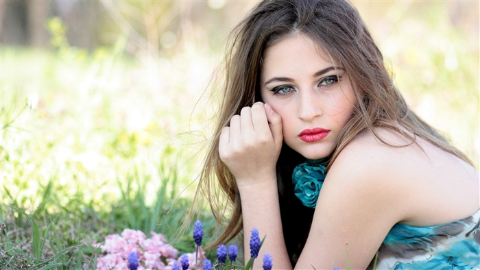 Woman with Blue Eyes and Red Lipstick Lying Down in Field