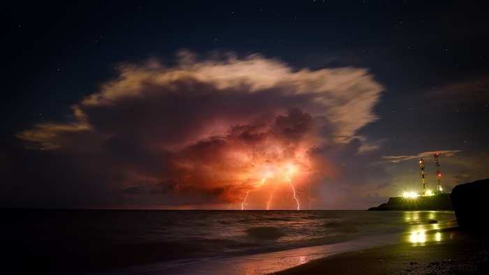 Nighttime Storm with Lightning over the Ocean Coastline
