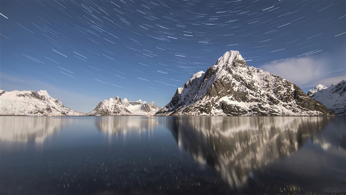 Star Trails Over Snowy Mountains Reflected in Lake