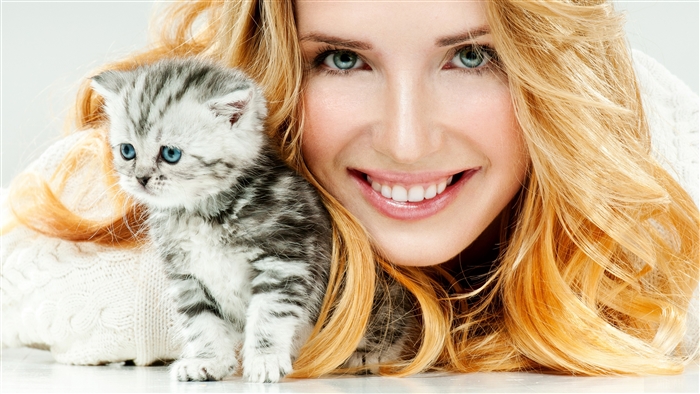 Woman with Blonde Hair and Blue Eyes Holding a Kitten 4K