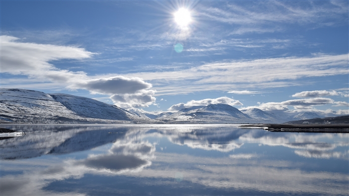 Snowy Mountains Reflecting in a Lake Under the Sun in Iceland 4K