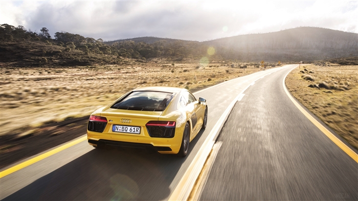 Yellow Audi R8 V10 driving on a scenic road