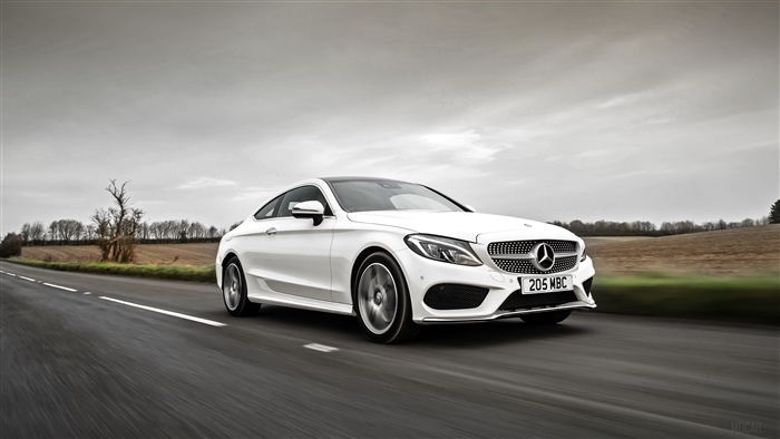 White Mercedes-Benz C-Class Coupe driving on a road