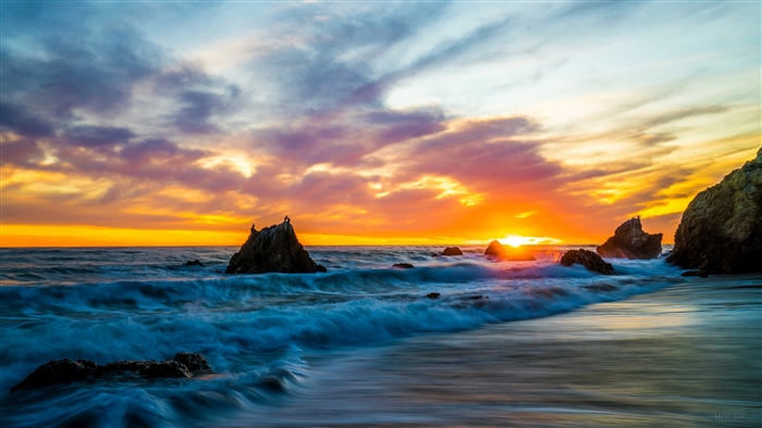 Sunset over the ocean with waves and rocks 4K