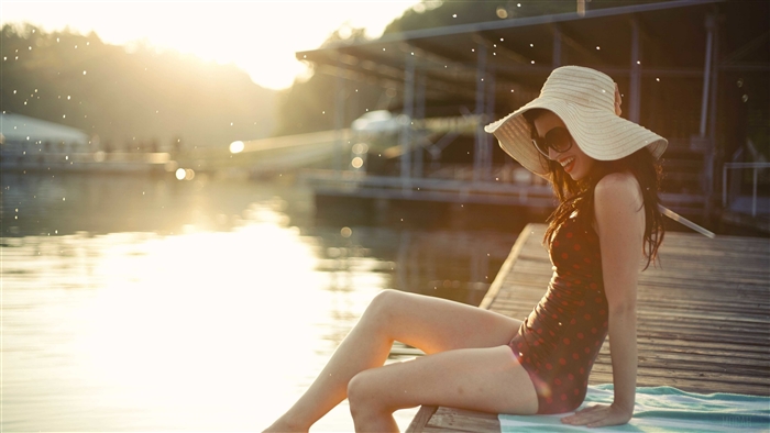 Woman in swimsuit and hat on a dock