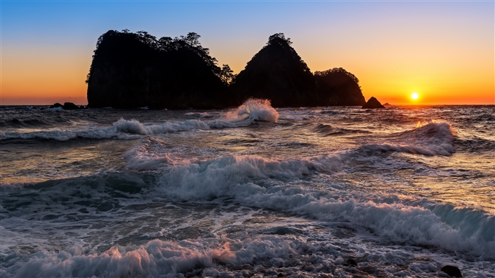 Sunset over the sea with waves and islands in Japan 4K