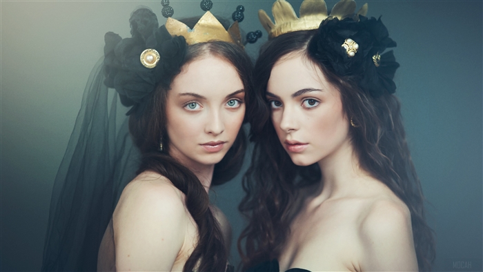 Two girls wearing crowns and black floral headpieces