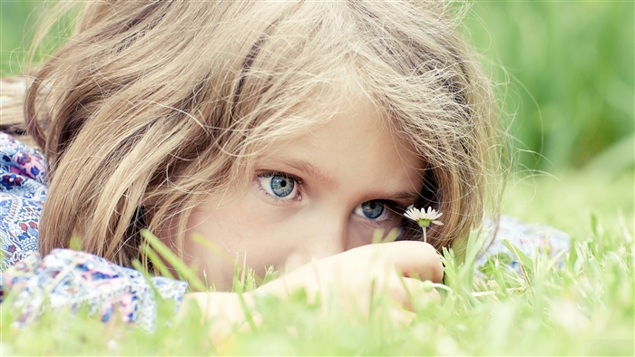 Close-up of a young girl's face in grass