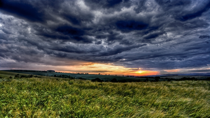 Stormy Sunset Over Grassy Hills