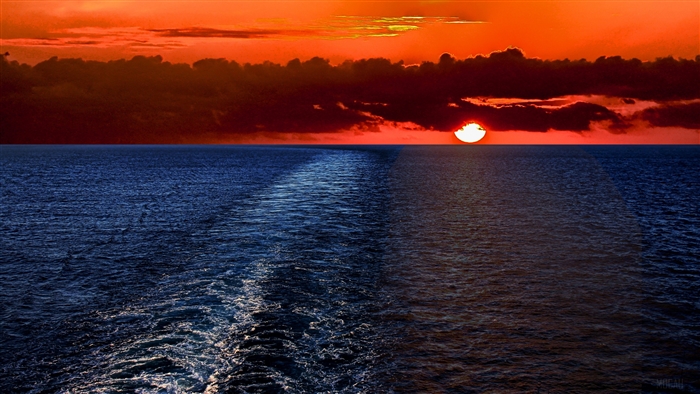 Sunset over the ocean with a wake
