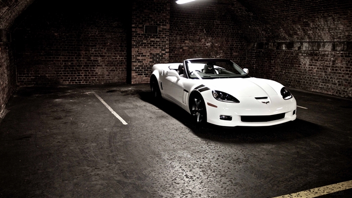 White convertible Corvette parked in a brick tunnel