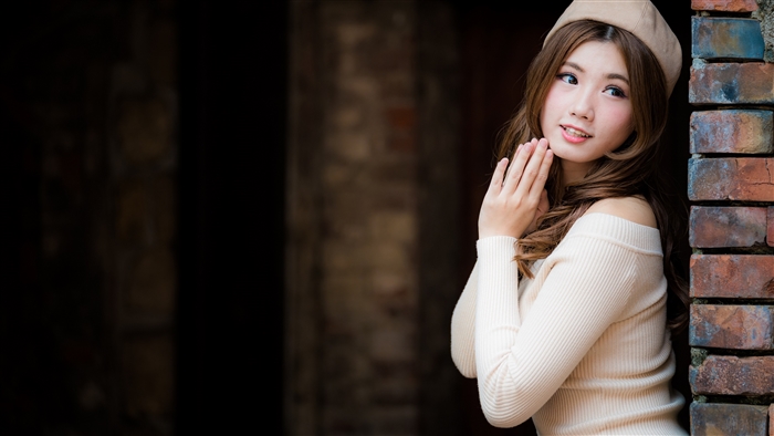 Asian woman wearing a beige sweater and beret