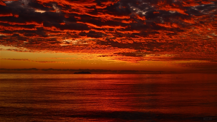 Sunset over the ocean with dramatic clouds