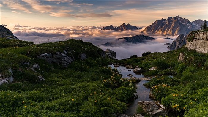 Mountain peaks above clouds at sunrise 4K