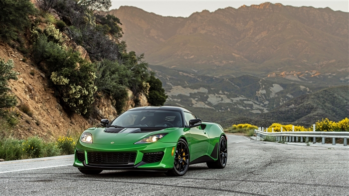 Green Lotus Evora GT driving on a mountain road