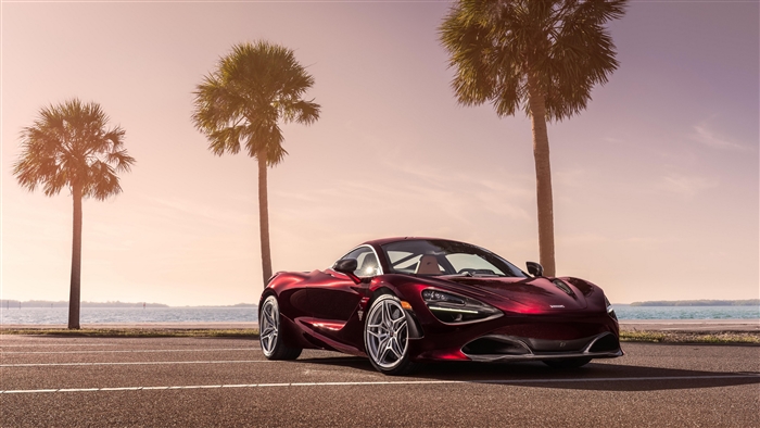Red McLaren 720S Supercar parked by the ocean with palm trees