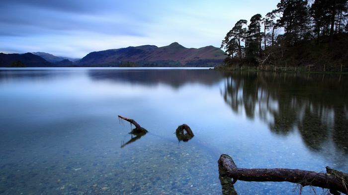 Long exposure of a lake with mountains and trees